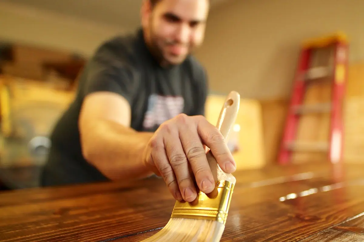 Artisan appliquant une protection sur le bois