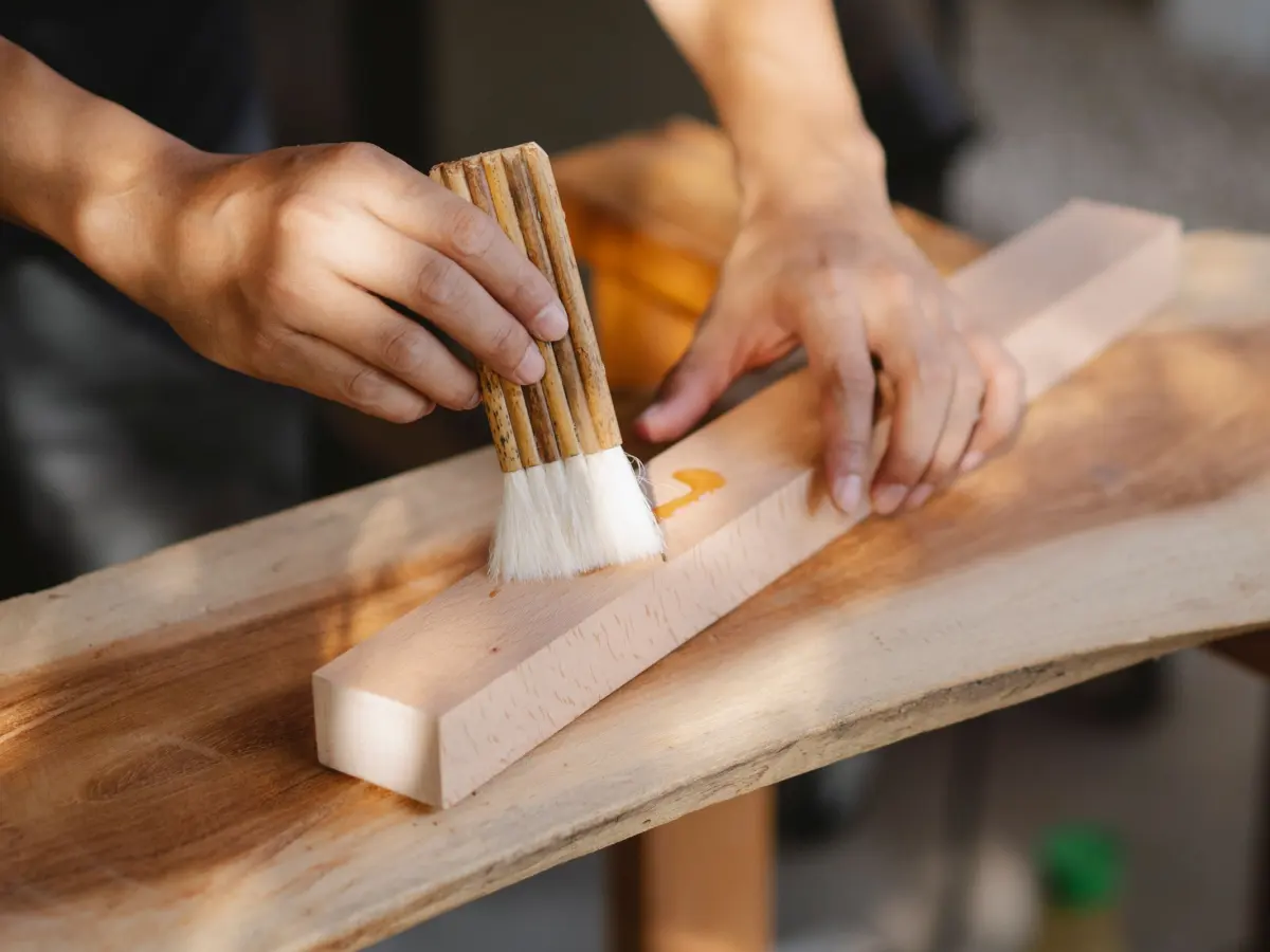 Application d'un saturateur au pinceau sur une lame en bois