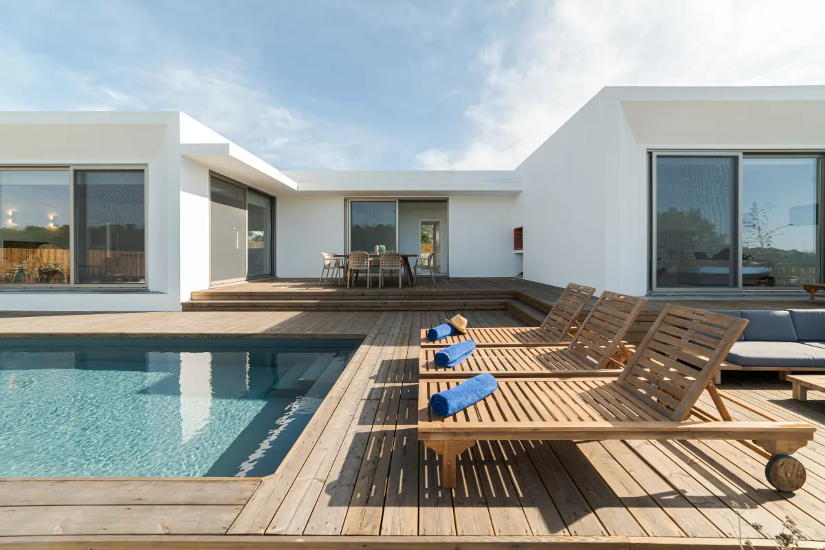Terrasse en bois aux Combes à Antibes : terrasse en bois et chaises longues au bord de la piscine
